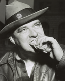 Photograph showing a head-and-shoulder portrait of longshoreman, Robert Malak, eating a hot dog at Coney Island.