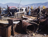 3 men working in the scrap yard in Butte Montana. The scrap drive most likely was for the war effort.