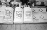 tea table flour, the piqua milling co blue ribbon flour, silver flake flour and purity plates all shown in a store window.