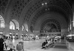 Passengers seated in long benches in the waiting room of Union Station, Washington, D.C.