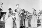 5 musicians in togas playing brass instruments