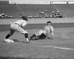 The Great Bambino slides into third base for the New York Yankees in a game against the Washington Senators. Oswald Bluege is at third. The play came  in the fourth inning on a fly out by Bob Meusel.