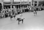 Man in full native head dress rides a horse in the Biilings Montana go west parade.