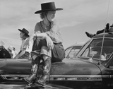 Girl sits on a Chevy Deluxe at a rodeo in Ashland Montana in the 1940's